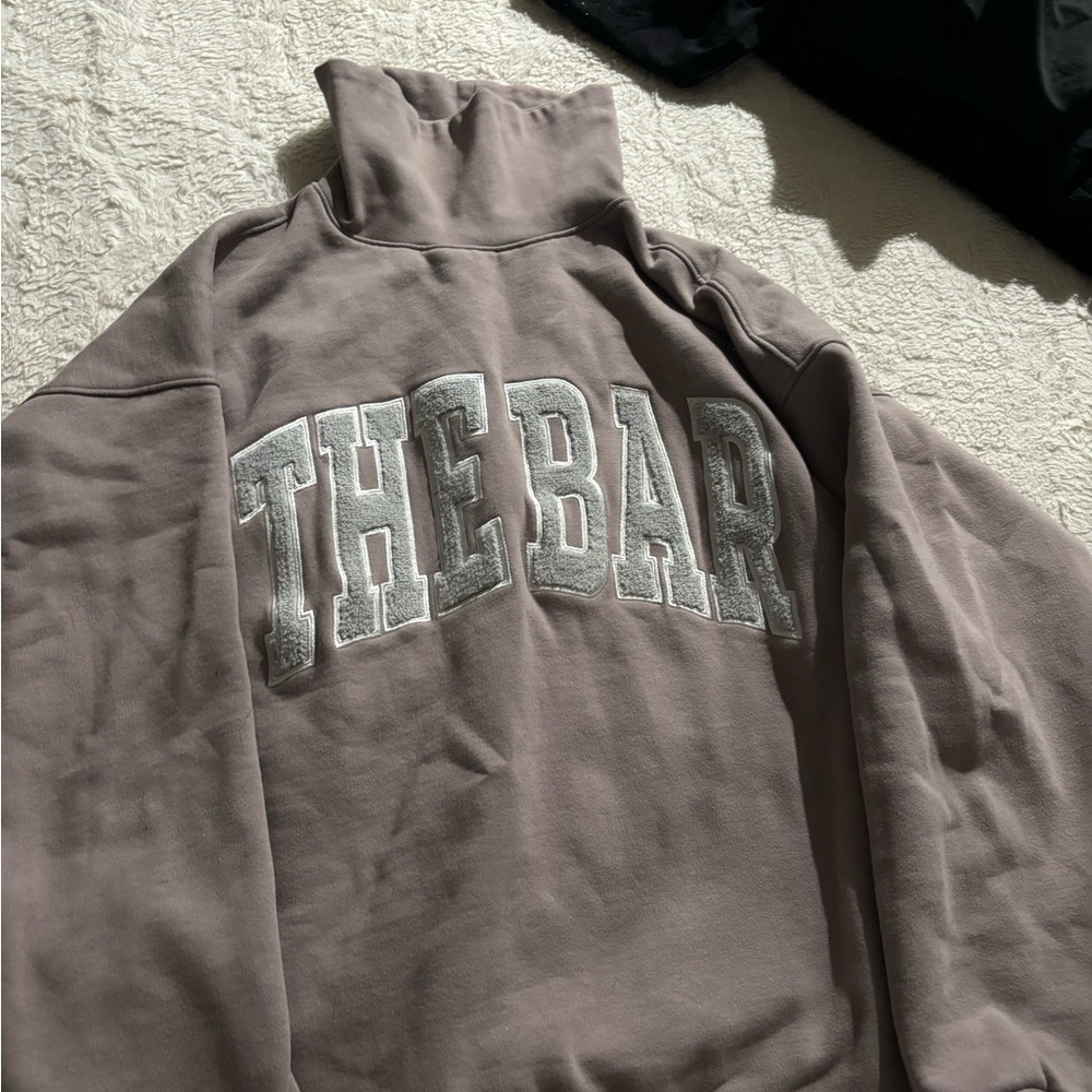 The Bar High Neck Sweatshirt w/ Gray Appliqué.